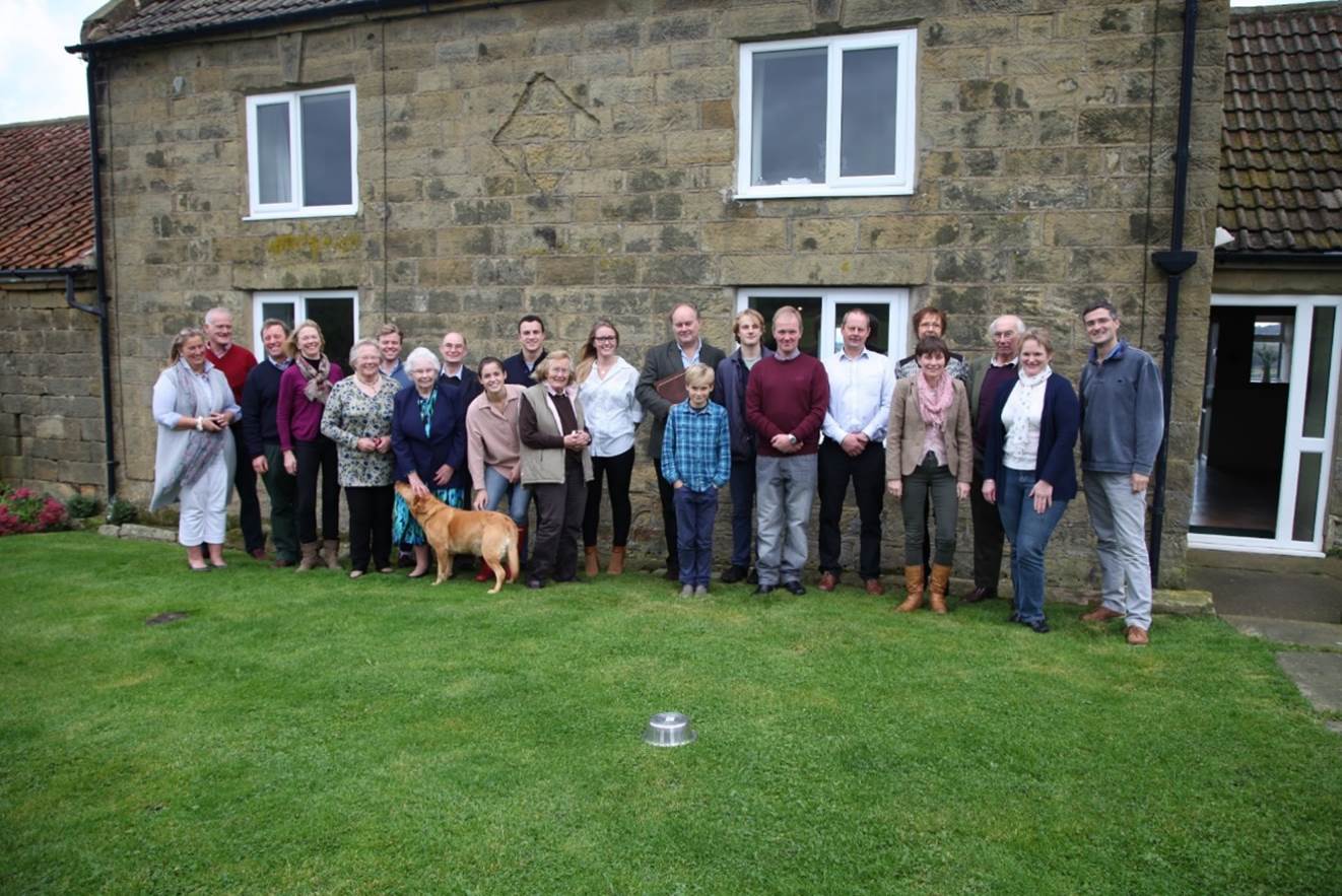 A group of people standing in front of a building

Description automatically generated