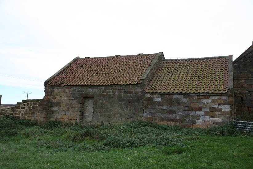 A stone house with a red roof

Description automatically generated