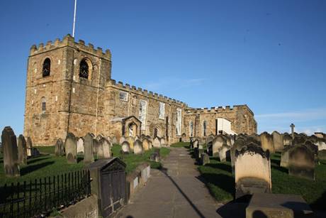 A stone building with a cemetery

Description automatically generated